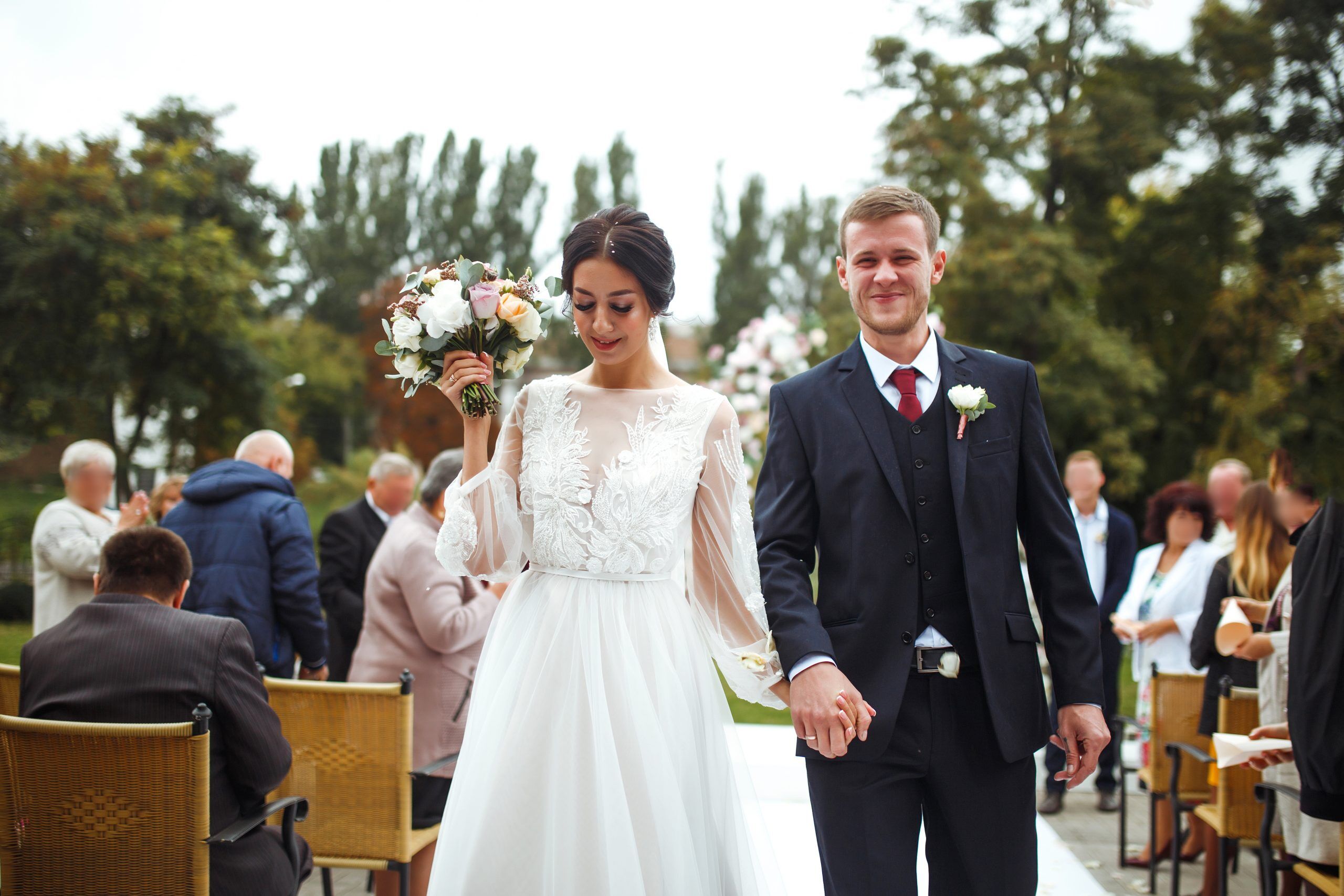 Happy groom and beautiful bride at a wedding ceremony under the arch decorated with flowers. Wedding day.