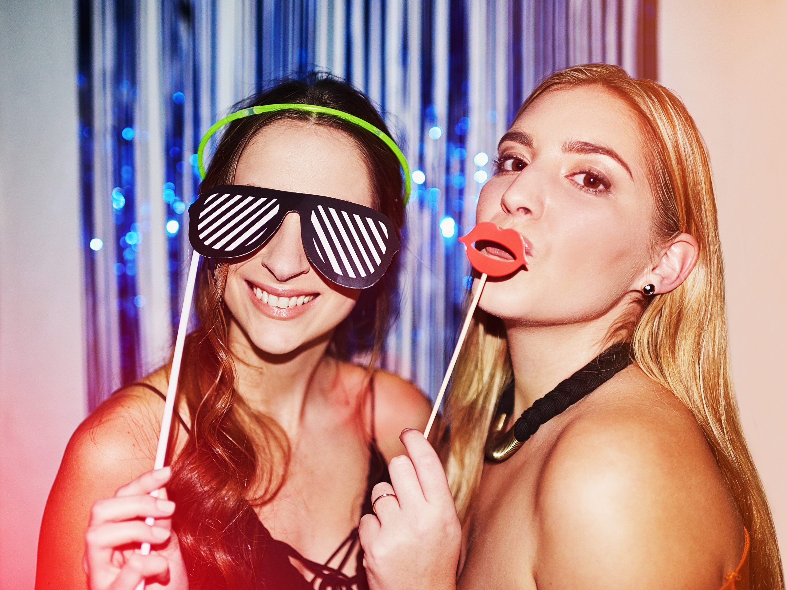 TGIF. Shot of two beautiful young women having fun with props in a photobooth